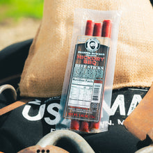 Load image into Gallery viewer, Packaged beef sticks with a label on a rustic background
